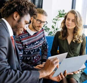 A diverse group of young professionals engaged in a business meeting inside a modern office.